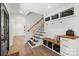 Inviting foyer with custom built-ins, bench, and drawers with black iron staircase at 9830 Spring Harvest Dr, Mint Hill, NC 28227