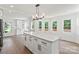 Bright kitchen features an island, white cabinets, stainless steel appliances, and wood floors at 9830 Spring Harvest Dr, Mint Hill, NC 28227