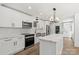Bright kitchen featuring white cabinets, a center island with marble countertops, and stainless steel appliances at 9830 Spring Harvest Dr, Mint Hill, NC 28227