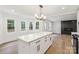 Bright open kitchen with marble countertop island and hardwood floors, providing ample workspace and a social hub at 9830 Spring Harvest Dr, Mint Hill, NC 28227