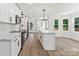 Bright kitchen features an island, white cabinets, stainless steel appliances, and wood floors at 9830 Spring Harvest Dr, Mint Hill, NC 28227