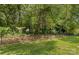 Lush backyard featuring a black metal fence and mature trees at 1011 Wadsworth Ln, Indian Trail, NC 28079