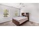 Bright bedroom featuring a ceiling fan, carpeted floor, and natural light from two windows at 1011 Wadsworth Ln, Indian Trail, NC 28079