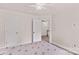 This is a bright bedroom with carpeted floor and neutral walls, adjoining a room with a black banister at 1011 Wadsworth Ln, Indian Trail, NC 28079