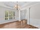 Formal dining room with coffered ceilings, hardwood floors, wainscoting and large window with natural light at 1011 Wadsworth Ln, Indian Trail, NC 28079