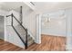 Inviting foyer with hardwood floors, staircase, and view into a dining room with chandelier at 1011 Wadsworth Ln, Indian Trail, NC 28079