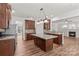 Open kitchen with wood floors, island, breakfast bar, fireplace and stainless appliances at 1011 Wadsworth Ln, Indian Trail, NC 28079