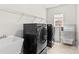 Laundry room with black washer and dryer and utility sink at 1011 Wadsworth Ln, Indian Trail, NC 28079
