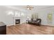 Cozy living room featuring a fireplace, ceiling fan, hardwood floors, and plenty of natural light at 1011 Wadsworth Ln, Indian Trail, NC 28079