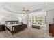 Spacious main bedroom with tray ceiling, ceiling fan, sitting area, and large windows at 1011 Wadsworth Ln, Indian Trail, NC 28079