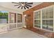 A covered patio featuring red brick, white railing, white trim, and view of the backyard at 1011 Wadsworth Ln, Indian Trail, NC 28079