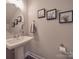 Stylish half-bathroom with a modern pedestal sink, elegant mirror, and neutral decor at 1016 Forest Dr, Marshville, NC 28103