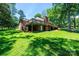 Brick home with a large wooden deck featuring stairs, set in a grassy backyard with mature trees at 1036 11Th Street Circle Nw Dr, Hickory, NC 28601