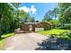 Brick home with a white back door leading to a concrete driveway, surrounded by green lawn and trees at 1036 11Th Street Circle Nw Dr, Hickory, NC 28601