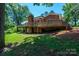 Spacious backyard with a large wooden deck, brick siding, and mature trees providing shade and privacy at 1036 11Th Street Circle Nw Dr, Hickory, NC 28601