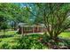 Charming brick home with inviting porch framed by lush greenery and mature tree at 1036 11Th Street Circle Nw Dr, Hickory, NC 28601