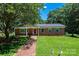 Well-maintained brick home with lush lawn, brick walkway, and mature trees offering ample shade at 1036 11Th Street Circle Nw Dr, Hickory, NC 28601