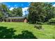 Charming single-story brick home with a lush green lawn and mature trees at 1036 11Th Street Circle Nw Dr, Hickory, NC 28601