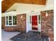 Inviting brick home featuring a red front door, black slate entryway, and a warm, wood-paneled porch ceiling at 1036 11Th Street Circle Nw Dr, Hickory, NC 28601
