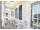 Front porch with white wicker chairs, blue print cushions and glass top table at 10509 Serape Rd, Charlotte, NC 28277