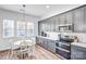 Kitchen with stainless steel appliances, gray cabinets with gold hardware, and a breakfast nook at 10509 Serape Rd, Charlotte, NC 28277
