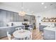 Well-lit kitchen featuring gray cabinetry, stainless steel appliances, and a round breakfast table at 10509 Serape Rd, Charlotte, NC 28277