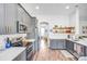 Bright kitchen features stainless steel appliances, gray cabinets with gold hardware, and wood flooring at 10509 Serape Rd, Charlotte, NC 28277