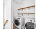 Convenient laundry room equipped with modern washer and dryer, shelving, and stylish flooring at 10509 Serape Rd, Charlotte, NC 28277