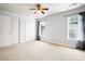 A spacious bedroom with a ceiling fan, windows, neutral carpet, and a double door closet at 11021 Dundarrach Ln # 40, Charlotte, NC 28277