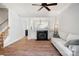 Bright living room featuring a fireplace, ceiling fan, hardwood floors, and a white sofa at 11021 Dundarrach Ln # 40, Charlotte, NC 28277