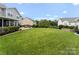Large backyard showcasing a lush green lawn, patio area, and mature landscaping at 112 Steeplechase Ave, Mooresville, NC 28117