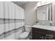 Bright bathroom with marble countertop vanity, a shower with striped curtain, and neutral wall paint at 112 Steeplechase Ave, Mooresville, NC 28117