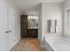 Bright bathroom features a soaking tub, dark wood vanity, and a large window providing natural light at 112 Steeplechase Ave, Mooresville, NC 28117