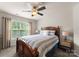 Cozy bedroom featuring a wood-frame bed, a ceiling fan, and natural light from the window at 112 Steeplechase Ave, Mooresville, NC 28117