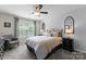 Comfortable bedroom with neutral carpet, a metal-frame bed, a ceiling fan, and ample natural light from the window at 112 Steeplechase Ave, Mooresville, NC 28117
