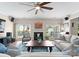 Cozy living room with a fireplace, plush seating, and an abundance of natural light at 112 Steeplechase Ave, Mooresville, NC 28117