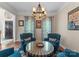 Inviting sitting area featuring blue upholstered chairs, a round table, and natural light from the windows at 112 Steeplechase Ave, Mooresville, NC 28117