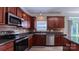 This well-equipped kitchen features dark wood cabinets, tile backsplash, and stainless appliances at 11514 Hattie Little St, Charlotte, NC 28269
