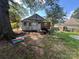 View of the rear of the home with overgrown yard and various items scattered around at 119 Hemlock Ave, Kannapolis, NC 28081