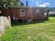 Back exterior of a brick home with an AC unit, windows, and partial fence at 119 Hemlock Ave, Kannapolis, NC 28081