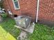 Side view of an outdoor AC unit next to a brick house with green grass at 119 Hemlock Ave, Kannapolis, NC 28081