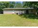 The back exterior shows a tan single story house, white door and sliding glass doors to a green lawn at 124 Julius Ln, Mooresville, NC 28117