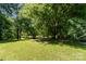 Lush, grassy backyard with mature trees providing ample shade and a serene, park-like setting at 124 Julius Ln, Mooresville, NC 28117