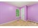 A compact bedroom has light purple walls, carpet floors, and a window with a view at 124 Julius Ln, Mooresville, NC 28117