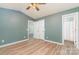 The bright blue bedroom has light wood floors, a ceiling fan, and two closets at 124 Julius Ln, Mooresville, NC 28117