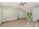 Spacious living room with laminate floors, vaulted ceiling, and natural light from windows and sliding glass doors at 124 Julius Ln, Mooresville, NC 28117