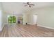 Open concept living space with laminate floors, leading to the kitchen area with breakfast bar and sliding glass doors at 124 Julius Ln, Mooresville, NC 28117