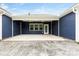 Covered patio area with blue siding, leading to a stone-patterned design and backyard access at 1300 Dali Blvd, Mount Holly, NC 28120