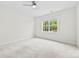 A serene bedroom featuring a ceiling fan and a large window with picturesque views of lush trees at 1300 Dali Blvd, Mount Holly, NC 28120