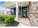 Inviting front porch with dark trim, black shutters, brick accents and manicured landscaping at 1300 Dali Blvd, Mount Holly, NC 28120